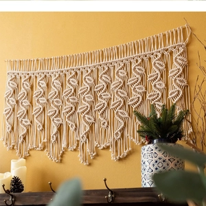 Détail d'une tapisserie bohème en coton tissé main avec motifs de feuilles et franges