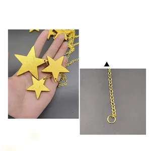 Detail of gold star wall decor hanging with metal chains and rings for home decoration