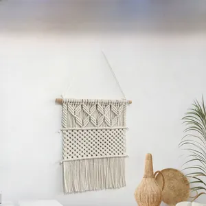 Détail de la tapisserie murale tissée main bohème avec franges en coton et tige en bois