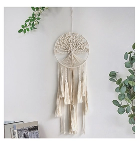 Detail of bohemian woven macrame wall hanging featuring a tree of life with long tassels