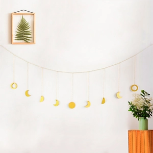 Detailed view of golden moon phase wall hanging with nine pendants on a metal chain