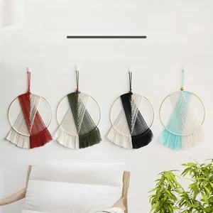Close-up of four multicolor macrame dream catchers hanging on a white wall for home decor