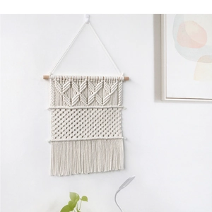 Détail de la tapisserie murale tissée bohème avec franges en coton et tige en bois