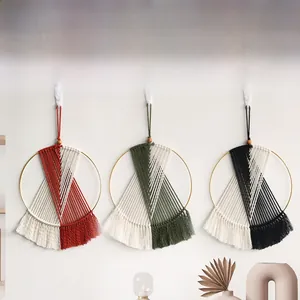 Detail of three-piece handmade woven wall hangings with golden metal rings and tassels