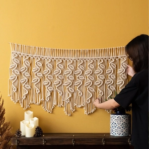 Grande décoration murale macramé bohème faite main avec motifs feuilles sur mur