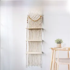 Detail of three-tier macrame wall hanging shelf with cotton rope and wooden trays