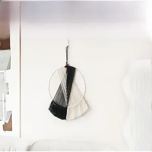 Detail of handcrafted bohemian macrame wall hanging with woven black and beige cotton ropes