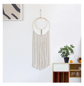 Detail of bohemian handmade woven cotton wall hanging with golden metal rings and wood beads