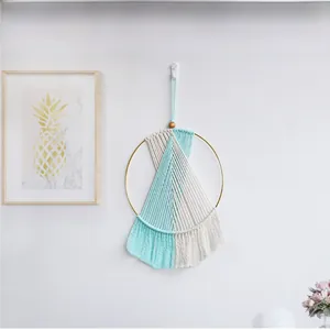 Detail of bohemian handmade woven wall hanging with mint green tassels and wooden beads