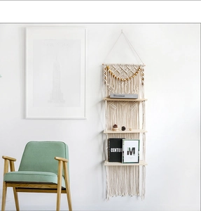 Detail of a 3-tier macrame wall shelf with handwoven cotton ropes and wooden boards