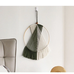 Detail of bohemian wall hanging with olive green and beige woven cotton tassels