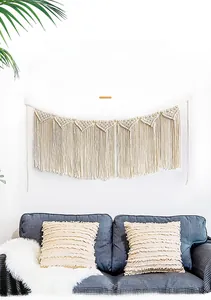 Close-up of handmade macrame wall hanging with triangle patterns and long tassels decor