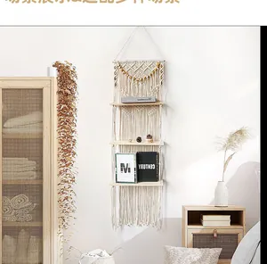 Detail of bohemian three-tier macrame wall shelf with cotton rope and wood boards