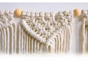 Detailed close-up of handmade Bohemian macrame wall hanging with cotton ropes and wooden beads