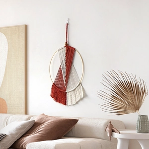 Handmade bohemian wall hanging with red and white cotton ropes and golden metal hoop