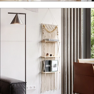 Detail of three-tier bohemian macrame wall shelf with hand-woven cotton rope and wood