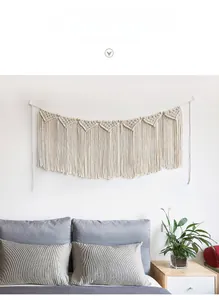 Detailed close-up of Bohemian hand-woven wall tapestry with fringe and wooden beads