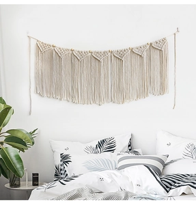 Detailed close-up of macramé wall hanging with cotton fringes and natural wooden beads