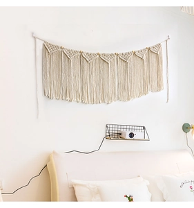 Detailed view of bohemian woven cotton tapestry with triangular macramé patterns and tassels