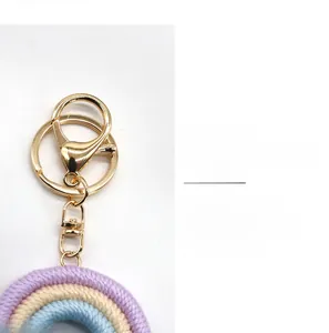 Dettaglio portachiavi arcobaleno boho intrecciato a mano con chiusura dorata e nappe