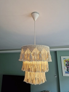 Detail of bohemian handmade woven cotton lampshade with triple tassels and wood beads