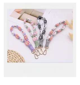Macro view of handmade woven flower phone straps with high-quality gold lobster clasps