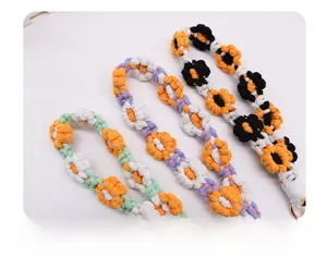 Close-up of hand-woven daisy flower charms with detailed cotton knitting and metal rings