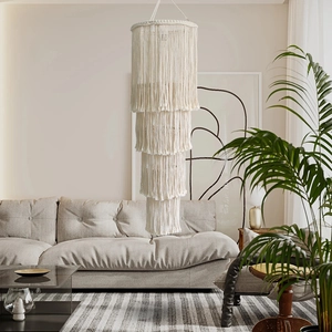 Detail of four-layered beige bohemian macrame lampshade with handcrafted cotton tassels