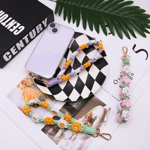 Handmade woven floral wrist strap with gold carabiner in purple and orange tones