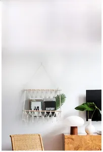 Close-up of a bohemian woven cotton rope wall hanging shelf with wooden rod for storage