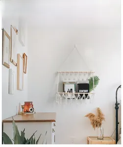 Close-up of bohemian hand-woven macrame wall magazine rack with natural wood and cotton rope