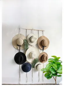 Detail of bohemian hand woven cotton rope hat organizer with sturdy wooden rod