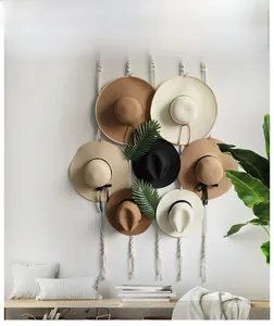 Detail of handwoven macrame hat organizer with raffia straw hats in neutral colors