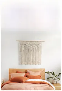 Detail of bohemian macrame wall hanging with intricate woven patterns and long cotton tassels
