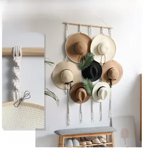 Detail of bohemian macrame hat organizer with wooden rod and cotton ropes for wall decor