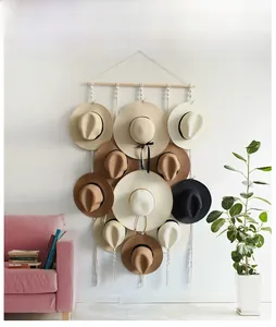 Detail of bohemian hand-woven tapestry hat organizer with wooden rod and cotton ropes