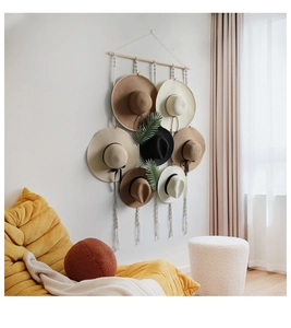 Detail of woven cotton tapestry wall mount rack storing seven various straw sun hats