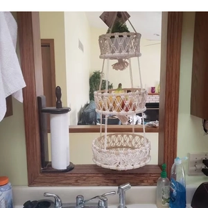 Detailed close-up of a three-tier handmade boho cotton rope hanging fruit basket