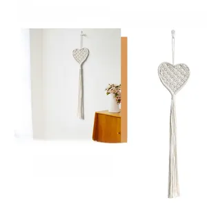 Macro detail of Bohemian style handmade cotton rope weaving and long tassel heart wall decor