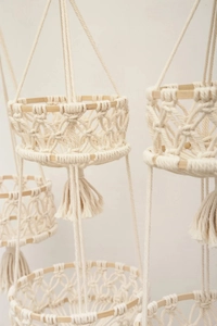 Detailed macro view of bohemian hand-woven macrame cotton fruit basket with wooden hoops
