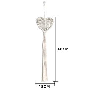 Detail of macramé woven heart wall hanging with fringe and dimensions 60x15 cm