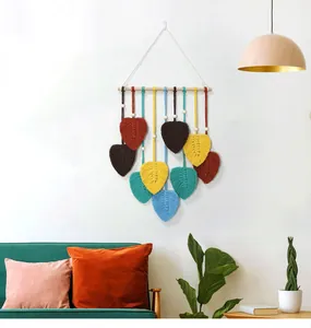 Détail d'une tapisserie tissée avec des feuilles colorées sur une tige en bois