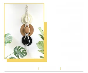 Detail of bohemian macramé hat organizer made with white cotton ropes for wall hanging