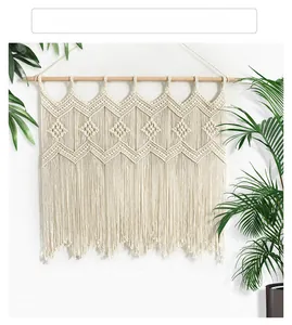 Detailed close-up of Bohemian hand-woven wall hanging with geometric diamond patterns and tassels