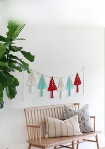 Detail of six handmade macrame Christmas tree ornaments with tassels on a banner