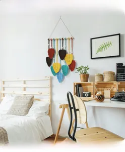 Détail de feuilles en macramé coloré sur bois pour décoration murale bohème