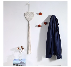 Detailed view of handmade woven cotton heart tapestry with long bohemian fringe accents