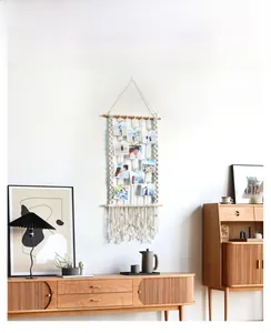 Detail of Nordic woven cotton tapestry photo display with wooden clips and tassels