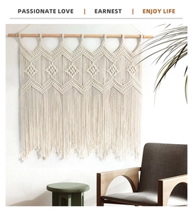 Close-up of bohemian macramé wall hanging with geometric woven textures and long cotton tassels