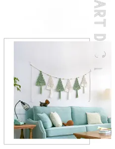 Detail of macrame Christmas tree wall hanging with green and cream tassels in home setting
